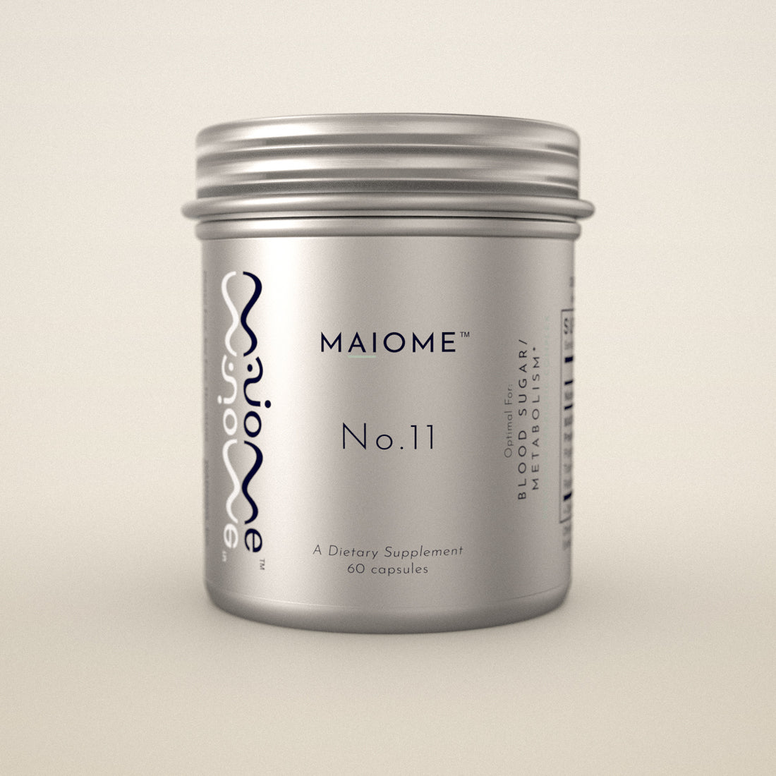 A silver metal supplement jar labeled MAIOME No.11, photographed against a clean, solid, warm off-white background.